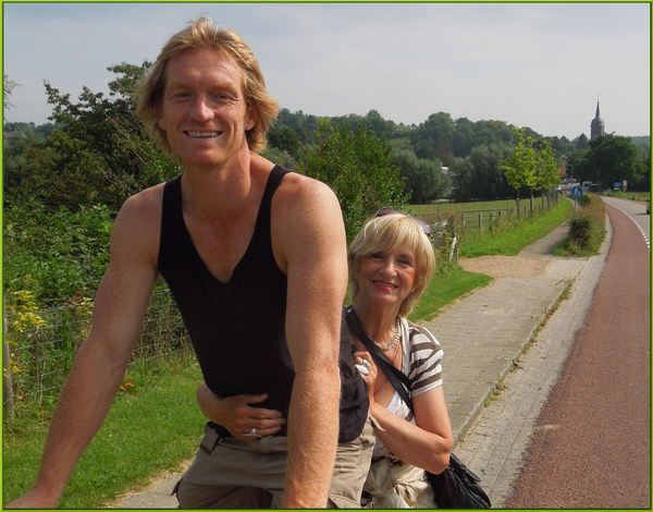 Corry achter op de fiets bij jongste zoon heuvel op in de zomer van 2012 in Limburg