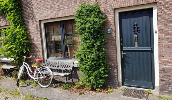 mama's hofje met witte fietsje en zadeldekje aan tuinbankje